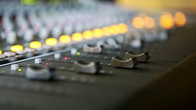 closeup musical electrical mixing consol guy hand touches digital faders