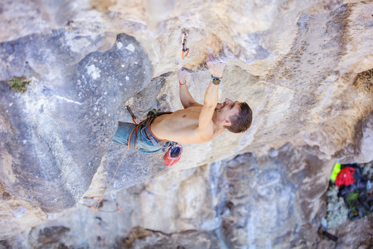 Male rock climber on a face of a cliff, view from above 
