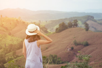 Fototapeta premium Asian woman is relax with beautiful mountain background in vintage tone