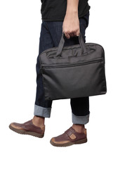 Young stylish in black trendy outfit with computer bag in hand