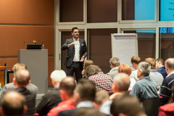 Speaker giving a talk in conference hall at business event. Audience at the conference hall....