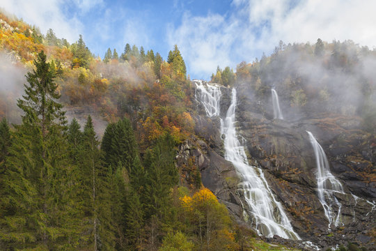 Nardis waterfalls surrounded with trees in Autumn, Trento, Italy 