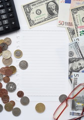 banknote and coin with empty notebook, glasses and calculator for background
