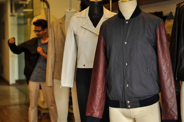 Photograph of beautiful leather jackets with buyer at a leather jacket store. No human figure included in the frame. 