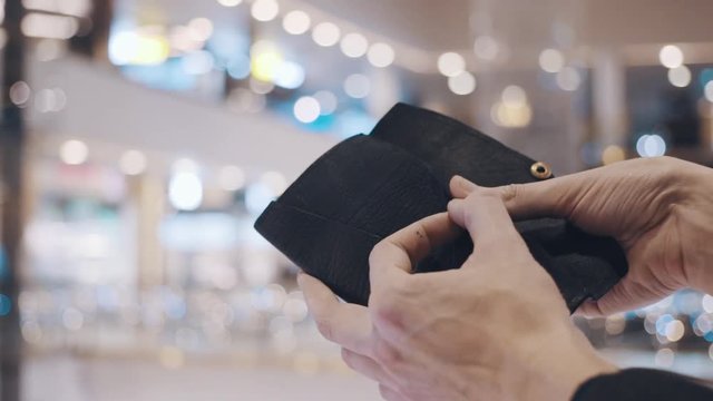 Man hands pulls out stiker with red SALE inscription from empty wallet. After Black Friday sales