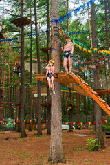 Fototapeta premium Woman and girl climbing in adventure park