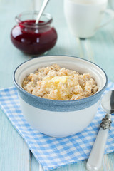 Oatmeal in a ceramic bowl for healthy breakfast on a light background. Selective focus.