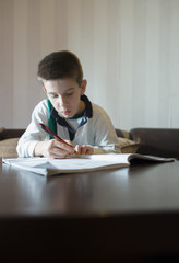 Child do his homework. Hand hold pen. Boy learning