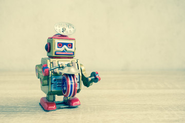 Fototapeta premium Old robot toy on wood table, vintage color style, vintage tone background.