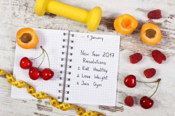 Plakat New year resolutions written in notebook on old board