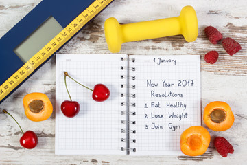 Naklejka na ściany i meble Electronic bathroom scale and new year resolutions written in notebook