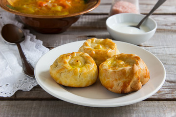 Russian traditional pies kurniki with cabbage soup. © Olga