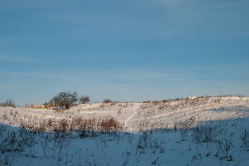 Beautiful winter landscape with snow-covered hills at sunset
