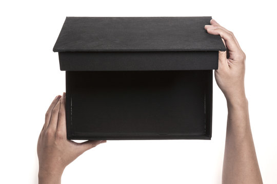 Two hands hold a empty(blank) black gift box and open isolated white