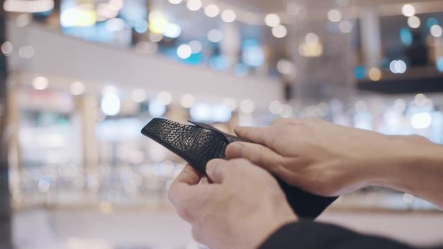 Man hands pulls out stiker with red SALE inscription from empty wallet. After Black Friday sales