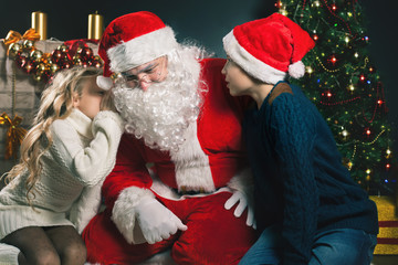 Fototapeta na wymiar Santa and children around the decorated Christmas tree. Wishes list