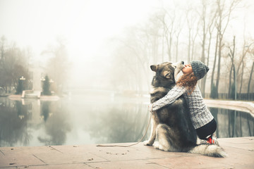 Image of young girl with her dog, alaskan malamute, outdoor