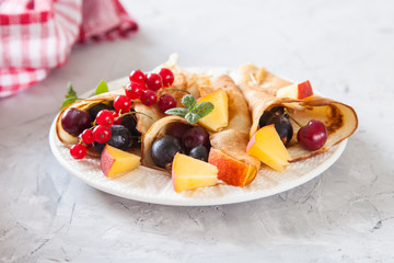 pancakes with berries in a plate on a table, selective focus