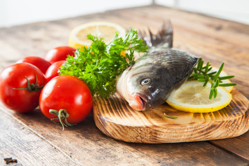 fish with a lemon and tomatoes on a table, selective focus