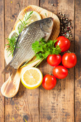 fish with a lemon and tomatoes on a table, selective focus,  top view