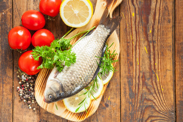 fish with a lemon and tomatoes on a table, selective focus,  top view