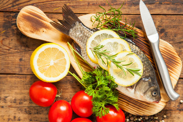 fish with a lemon and tomatoes on a table, selective focus,  top view