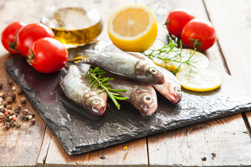 fish with a lemon and tomatoes on a table, selective focus