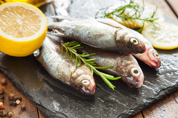 fish with a lemon and tomatoes on a table, selective focus