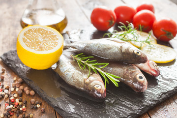fish with a lemon and tomatoes on a table, selective focus