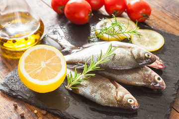 fish with a lemon and tomatoes on a table, selective focus