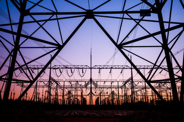 The silhouette of the evening electricity transmission pylon