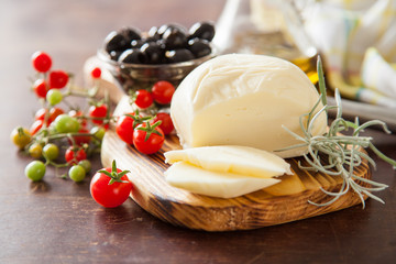 cheese, olives and tomatoes on a table, selective focus
