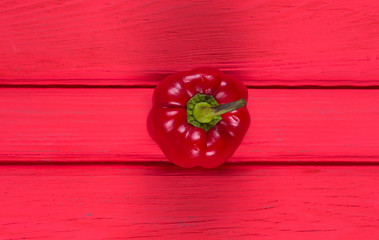 red bell pepper on a red wooden table