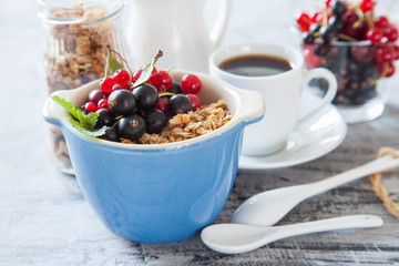 muesli with berries in a plate on a table, selective focus