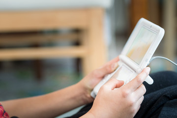 携帯ゲーム機で遊ぶ子供