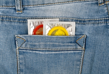 Colored condoms in a blue jeans pocket