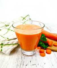 Juice carrot with vegetables and napkin on light board