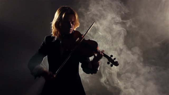 Woman Playing On Violin In Smoke.
