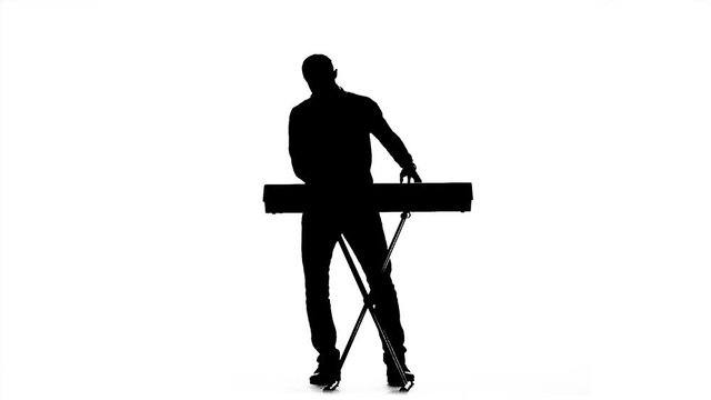 Silhouette of a man playing the piano. Slow motion