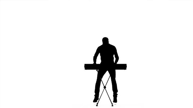 Silhouette of a man playing on electronic keyboard. Slow motion