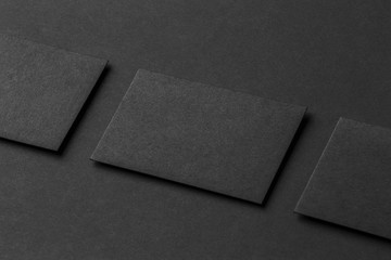 Mockup of three business cards at black textured paper