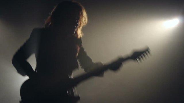 Silhouette Of Woman Playing On Guitar In Smoke