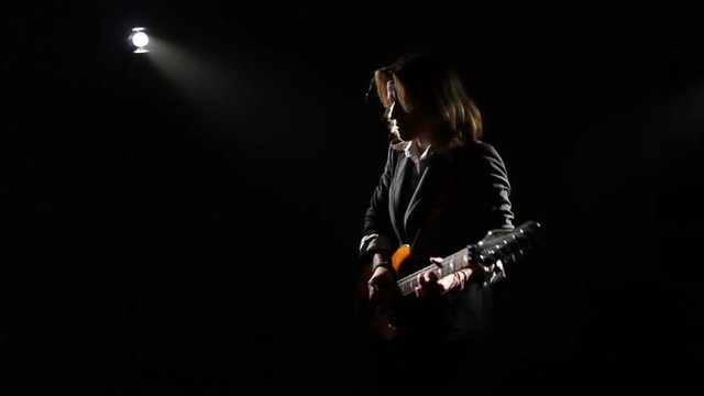 Woman Playing On Electric Guitar On Dark Stage