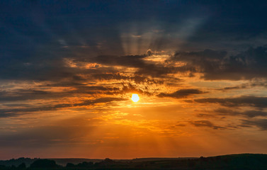 Fototapeta na wymiar sunset over green meadow, landscape, seen round the sun