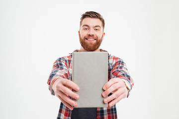 Smiling happy bearded man showing book cover to camera