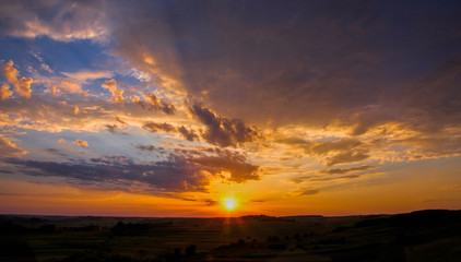 sunset over meadow with green grass