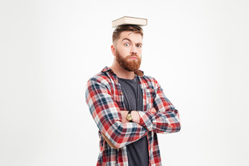 Young bearded man with book on his head having fun