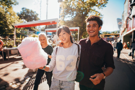 Young people with cotton candyfloss at amusement park
