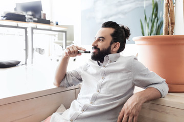 smiling man with beard and hair bun at office