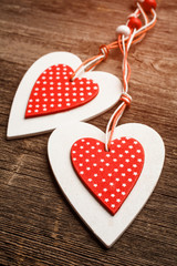 Fototapeta premium White and red sewed christmas hearts on wooden background